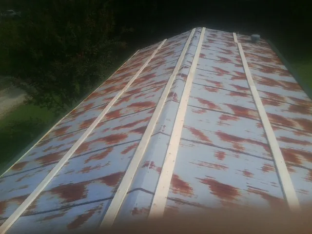 Rusted metal roof panels with new wood purlins before replacement — Storm Damage Roof Repair in Luther by Roofing Brothers